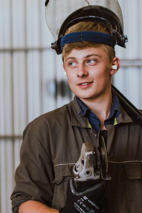 Image of ag mech student holding grinder and wearing safety equipment